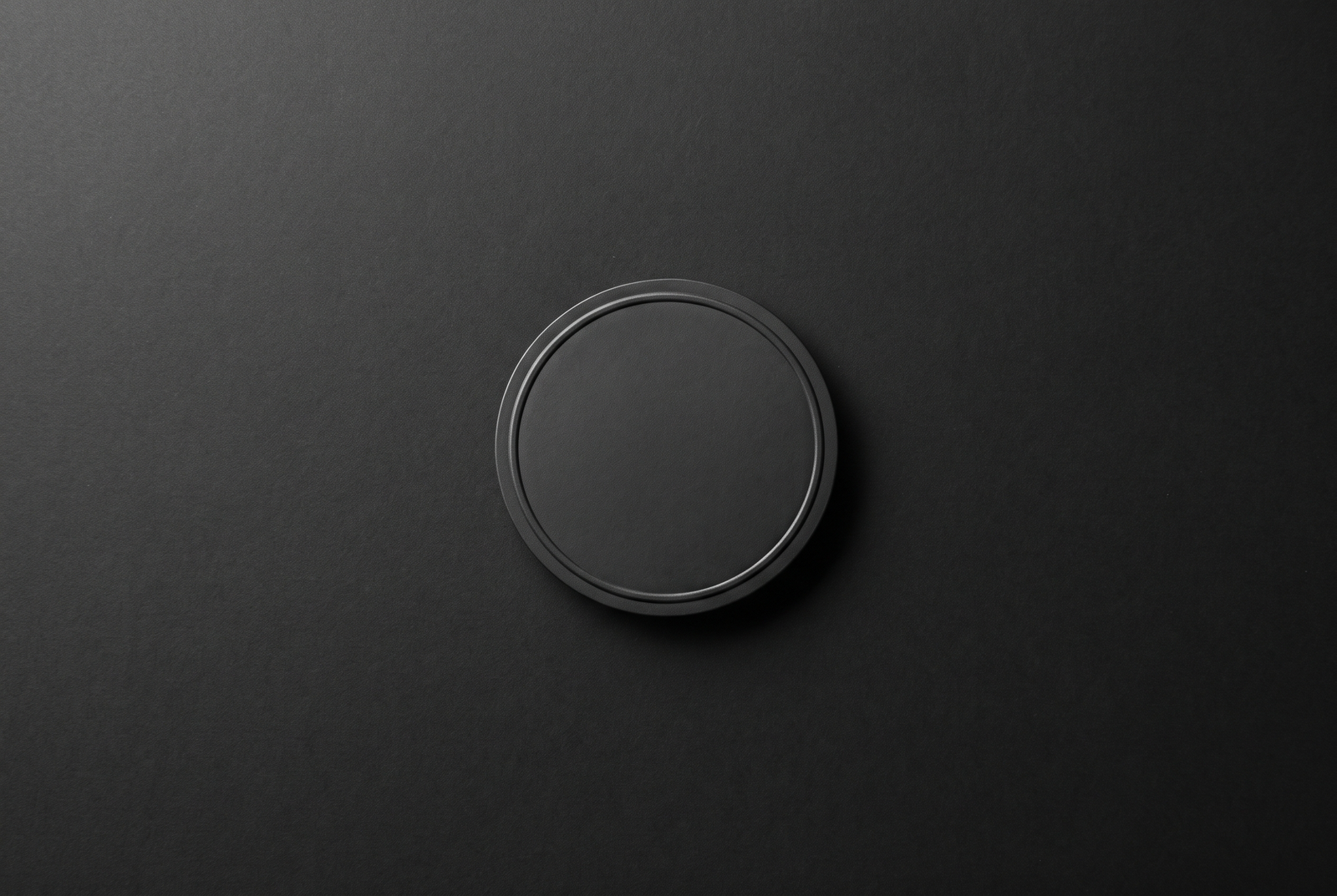 Minimal blank embossed seal on a dark background